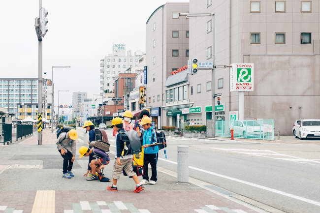 Дети в шлемах ходят по тротуару — стоковое фото