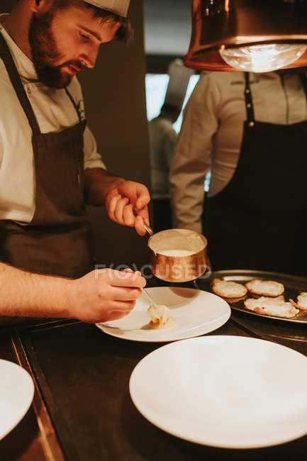 Шеф-кухар, який подає тарілку з соусом — стокове фото