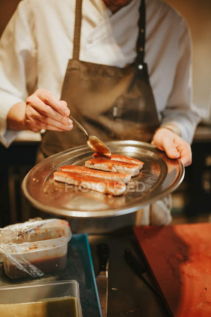 Cooks hands serving fried meat — Stock Photo