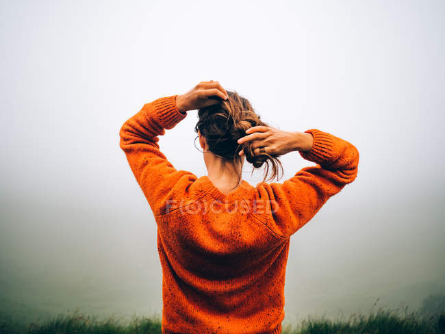 Mädchen justiert Haare über Nebel — Stockfoto