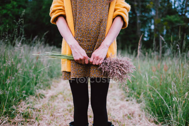 Femme tenant champ bouquet de fleurs — Photo de stock
