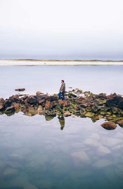 Homem de pé sobre rochas — Fotografia de Stock