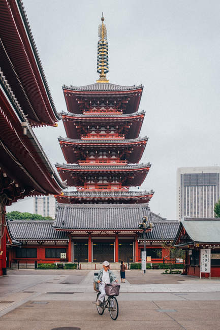 Person fährt Fahrrad in der Nähe des traditionellen Tempels — Stockfoto