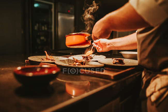 Chef poniendo salsa a las comidas - foto de stock