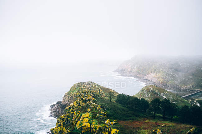 Niebla montaña orilla del mar - foto de stock