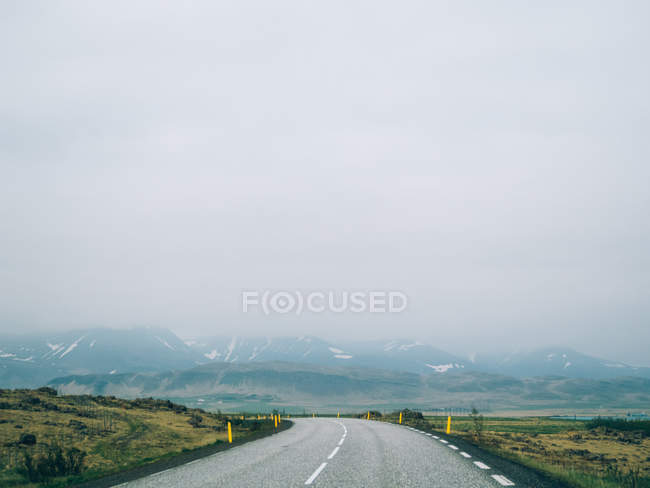 Road leading to foggy hills — Stock Photo