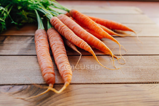 Pile of carrots on wooden table — Stock Photo