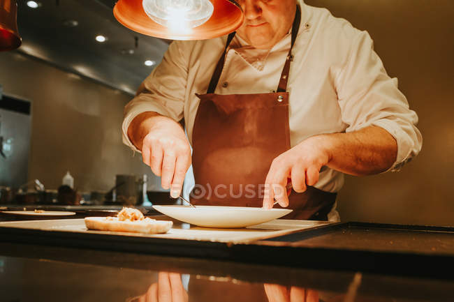 Professional cook preparing dish — Stock Photo