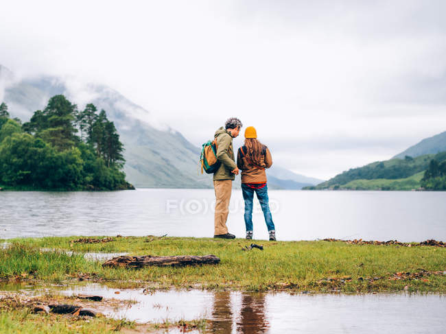 Couple of tourists looking in lake — Stock Photo