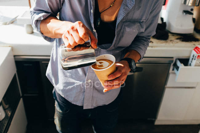 Persona versando latte al caffè — Foto stock