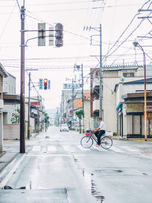 Homem cruzando estrada na bicicleta — Fotografia de Stock