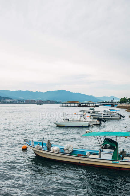 Varietà di barche parcheggiate vicino alla riva — Foto stock