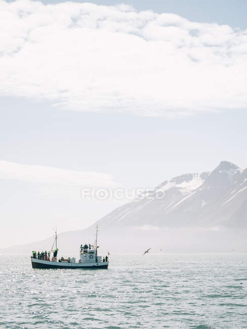 Лодка плывет рядом с горой — стоковое фото