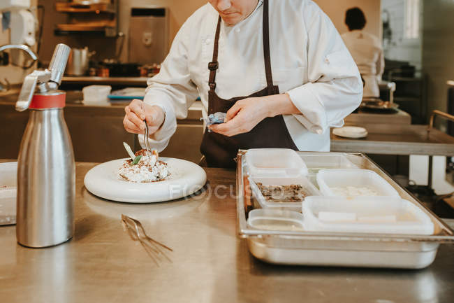 Cook decorating dessert on plate — Stock Photo