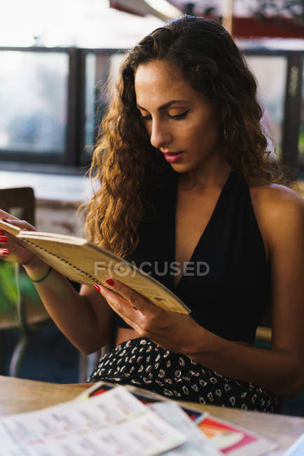 Девушка в кафе читает карту — стоковое фото