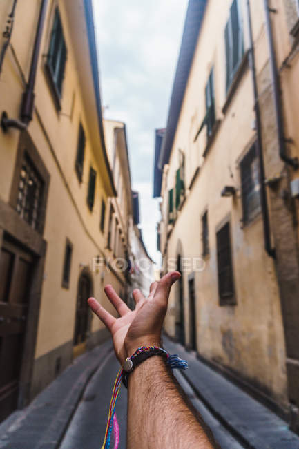 Crop male hand outstretched towards street, Florence — Stock Photo