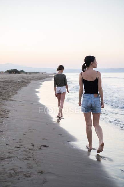 Frauen spazieren am Strand — Stockfoto