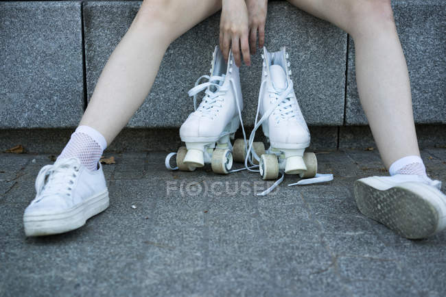 Crop girl in sneakers with roller skates — Stock Photo