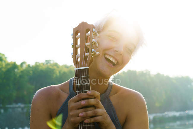 Дівчина позує з маленькою гітарою на вулиці — стокове фото