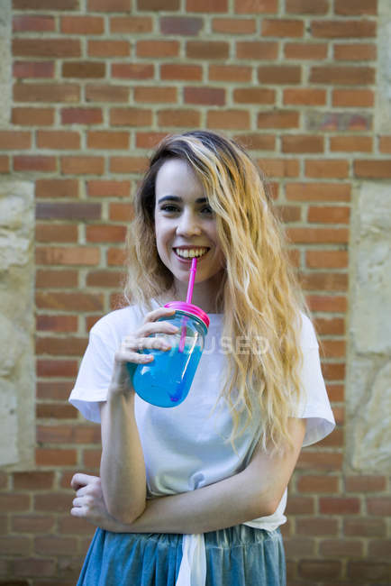 Laughing girl with drink — Stock Photo