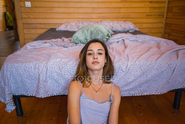Sanftes Mädchen posiert in der Nähe des Bettes — Stockfoto