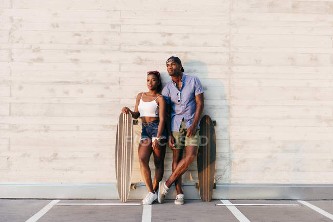 Stylish people with long boards — Stock Photo