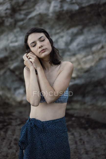Giovane donna fiduciosa posa vicino alle pietre — Foto stock