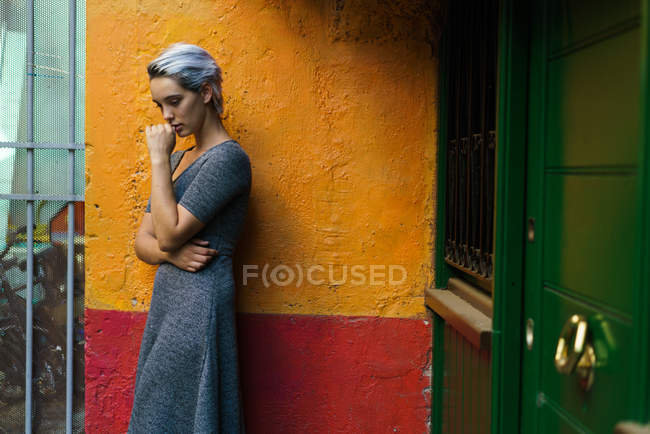 Жінка позує в барвистій стіні — стокове фото