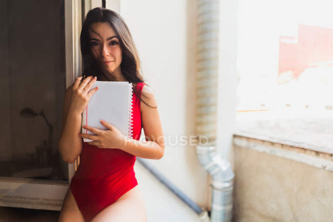 Chica encantadora posando con cuaderno - foto de stock