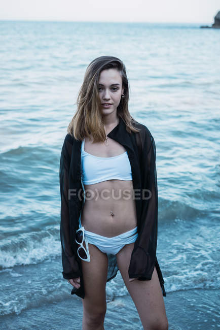 Giovane donna sensuale in posa sulla spiaggia — Foto stock