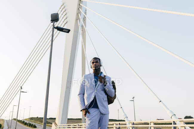 Elegante modelo masculino en traje con auriculares - foto de stock