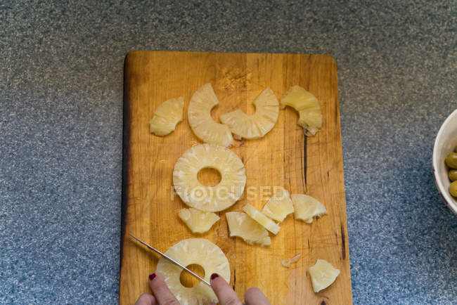 Erntefrau schneidet Ananas — Stockfoto