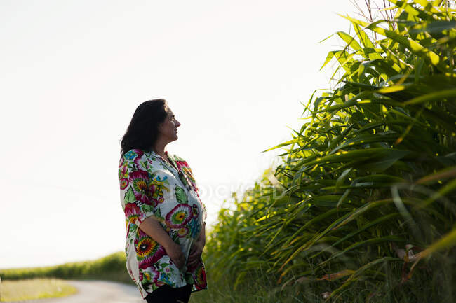Беременная женщина позирует на сельской дороге — стоковое фото