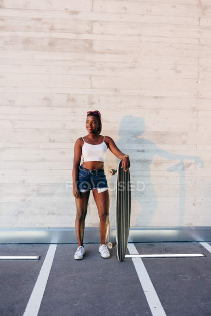 Stylish skateboarder posing at street — Stock Photo