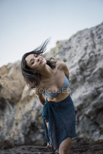 Jovem mulher confiante posando perto das pedras — Fotografia de Stock