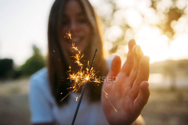 Smiling woman with sparkling light — Stock Photo