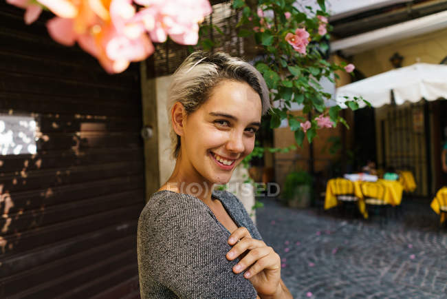 Mujer sonriente en el árbol floreciente - foto de stock