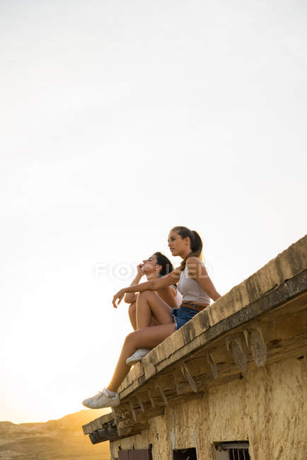 Mulheres bonitas sentadas no telhado — Fotografia de Stock