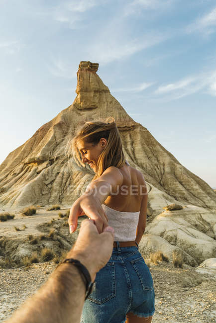 Woman holding hand of photographer at cliff — Stock Photo