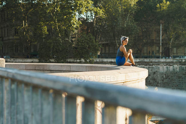 Stylish woman on fence of bridge — Stock Photo