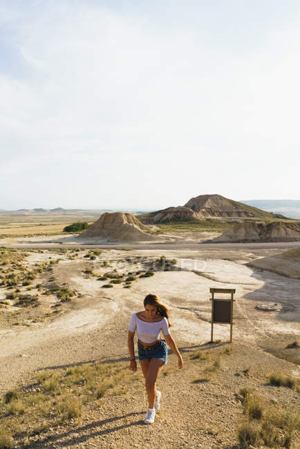 Женщина ходит по песчаному холму — стоковое фото