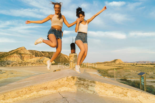 Donne felici che saltano sulla collina — Foto stock