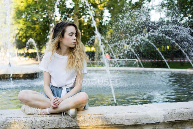 Teenager posiert auf Seite von Springbrunnen — Stockfoto