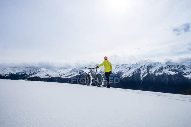Чоловік гуляє по горах з велосипедом — стокове фото