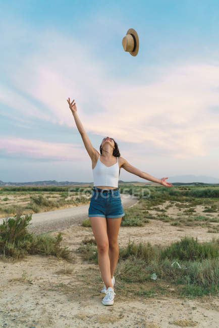 Woman throwing up hat in nature — Stock Photo