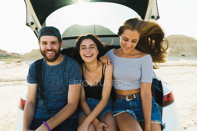 Friends sitting in car trunk — Stock Photo