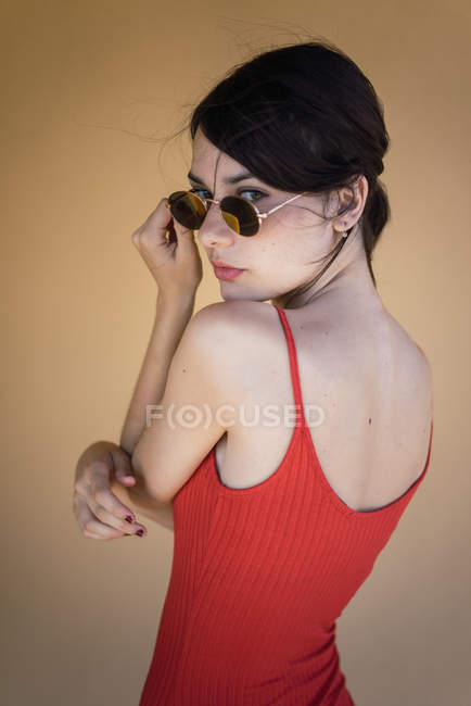 Девушка в красной одежде и солнечных очках позирует — стоковое фото