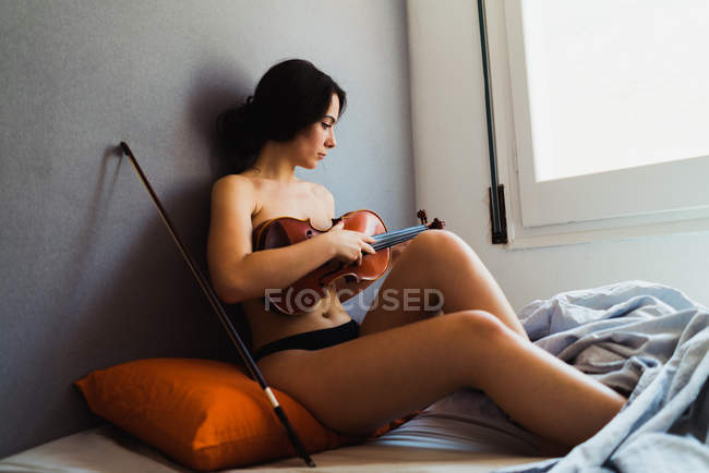 Гола жінка позує зі скрипкою — стокове фото