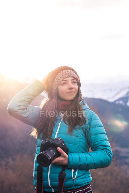 Girl with camera looking away — Stock Photo