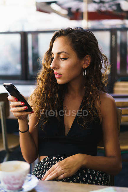 Девушка в кафе с телефоном — стоковое фото